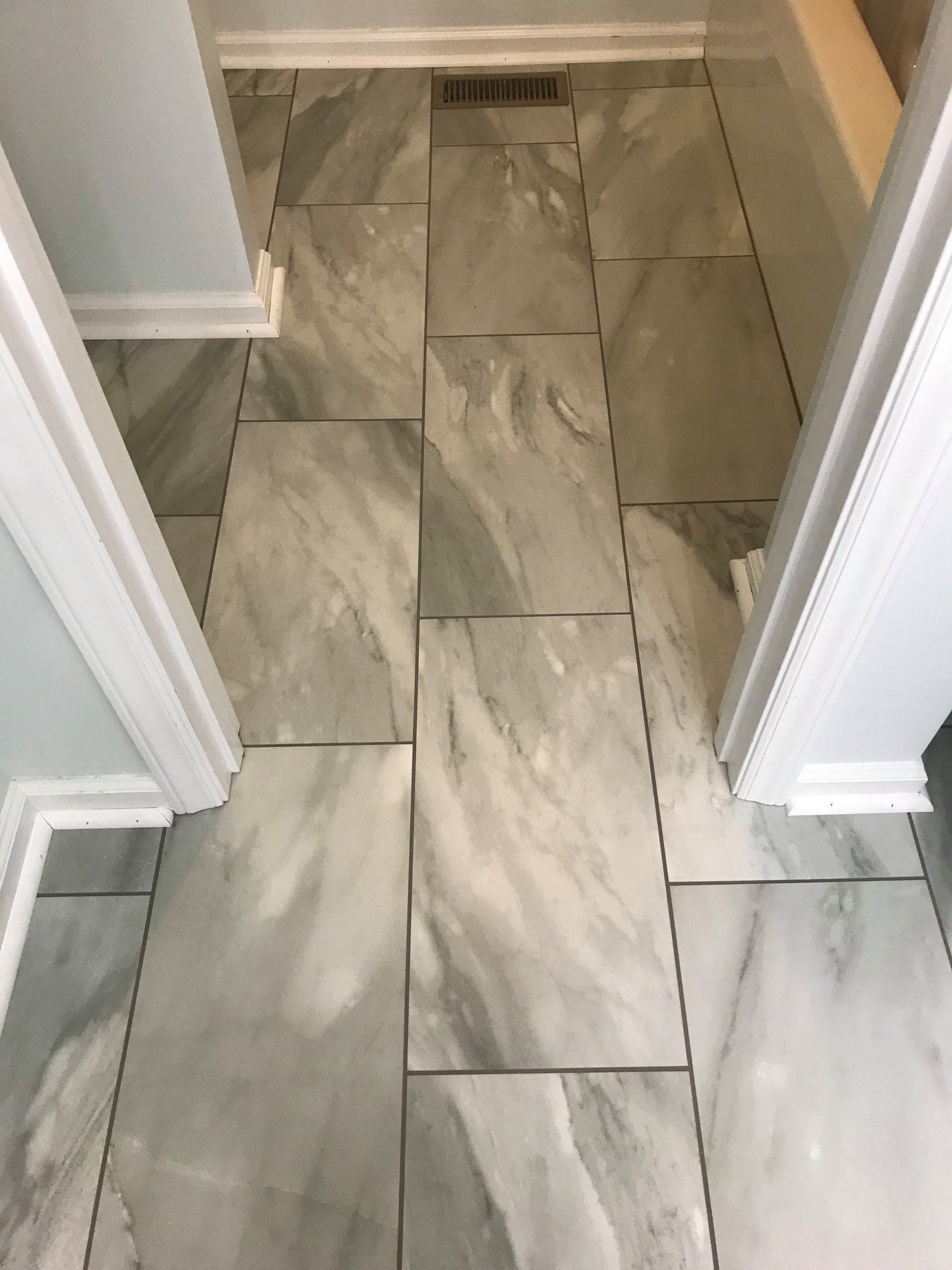 A bathroom with a tiled floor and a bathtub.