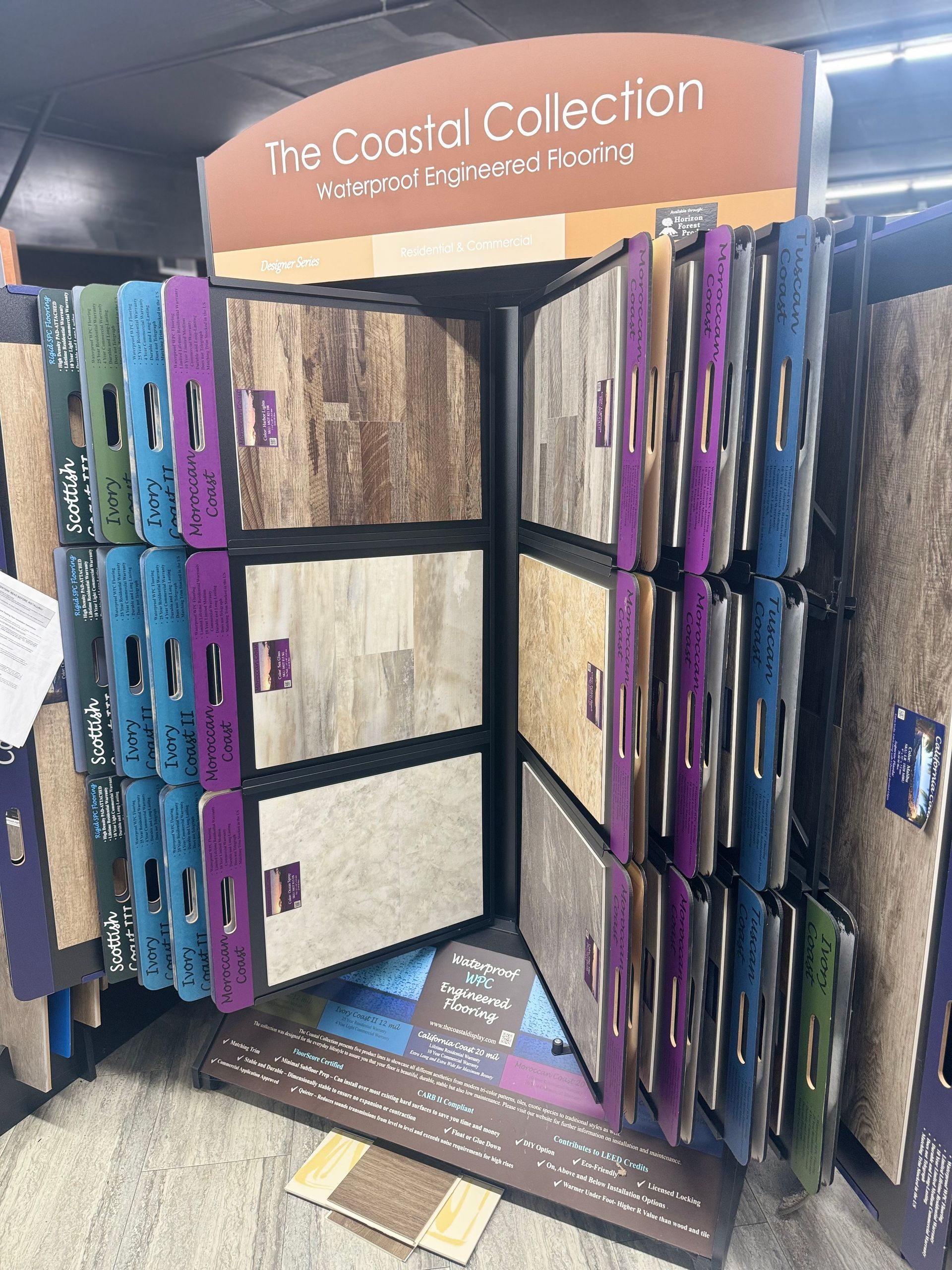 A display of carpets in a store with a sign that says the coastal collection.