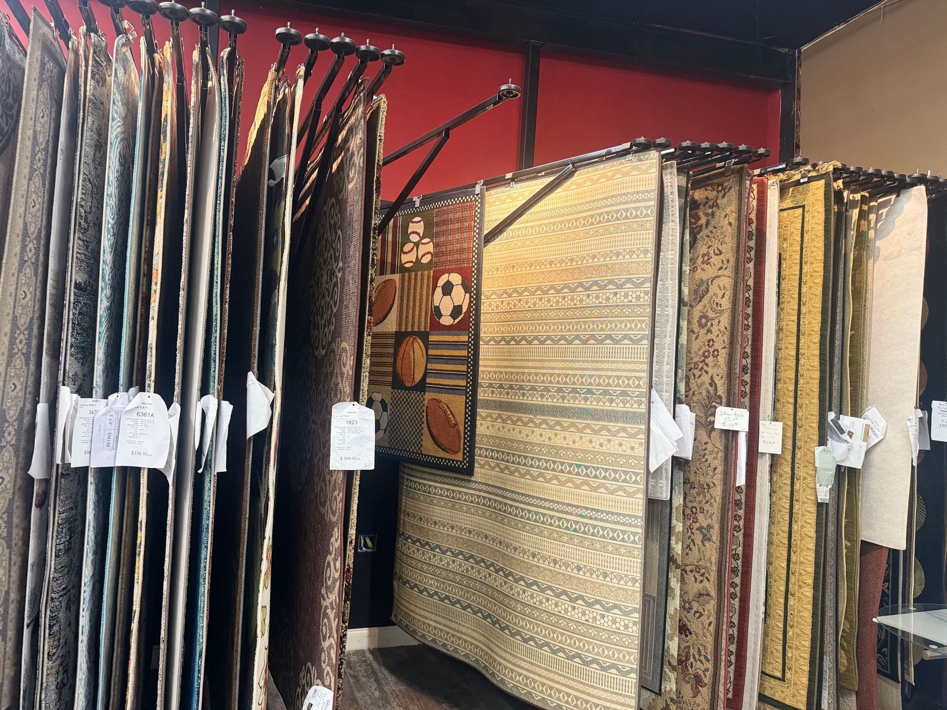 A room filled with lots of rugs hanging on racks.