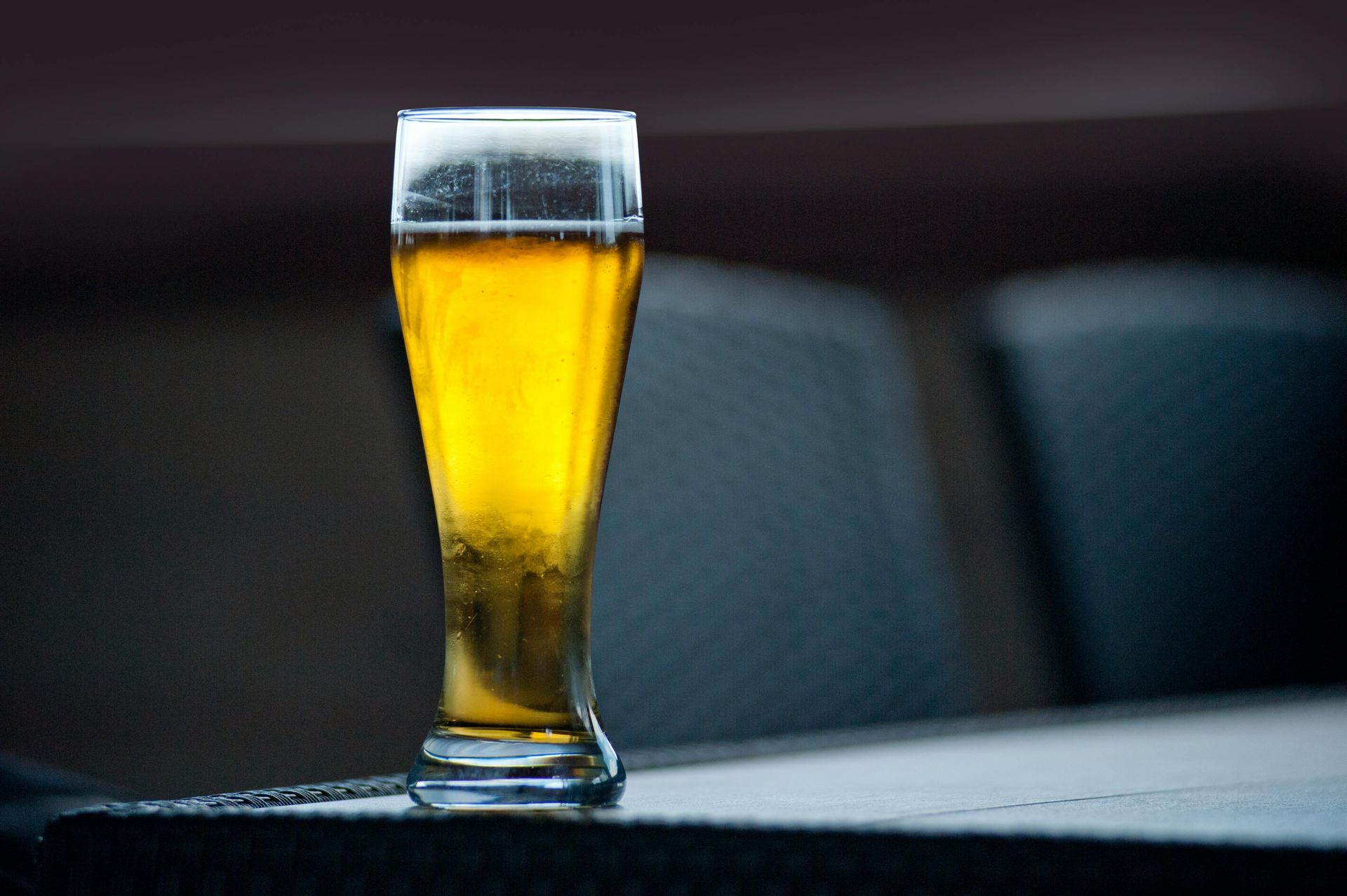 A glass of beer is sitting on a table.