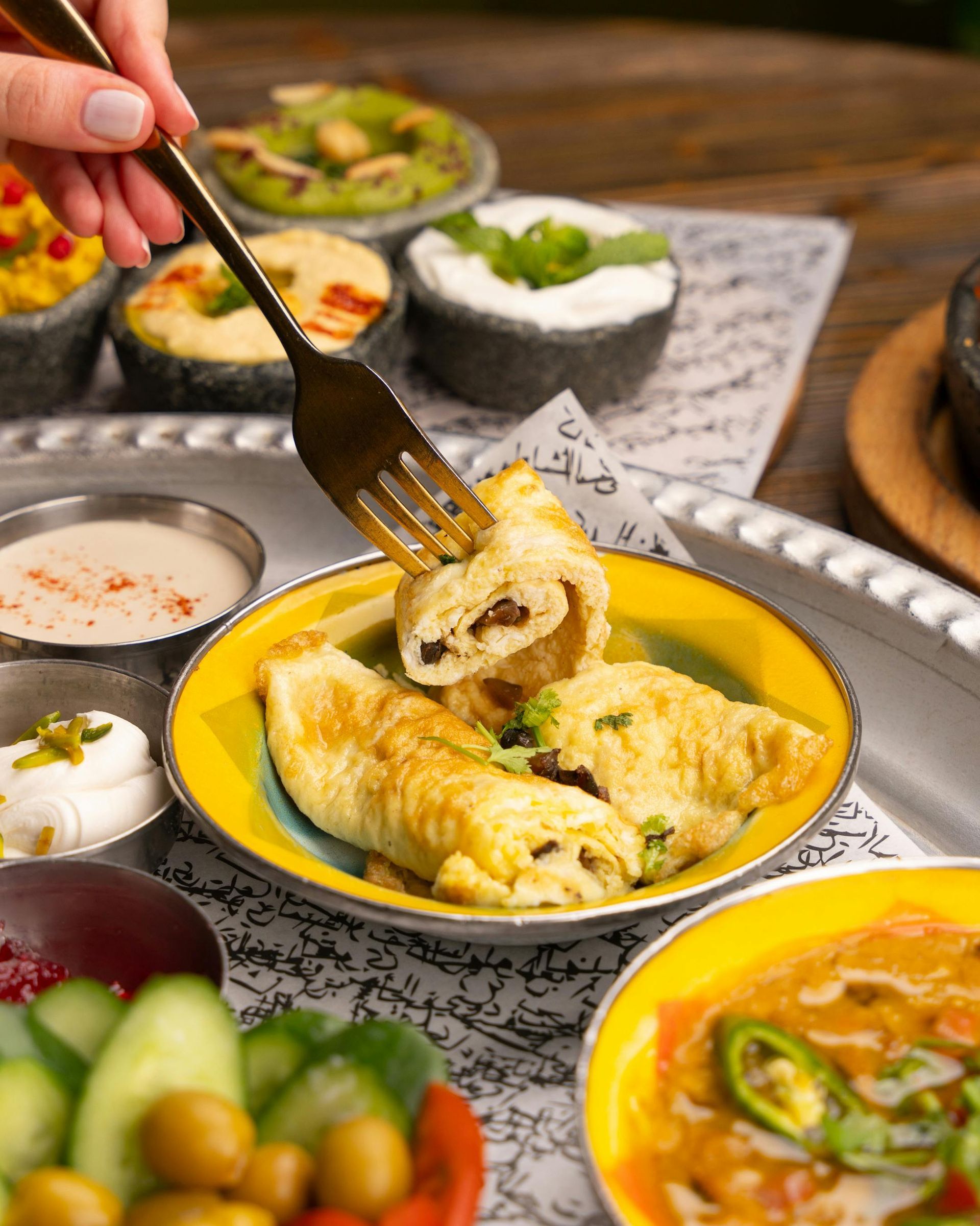 A person is holding a fork over a plate of food.