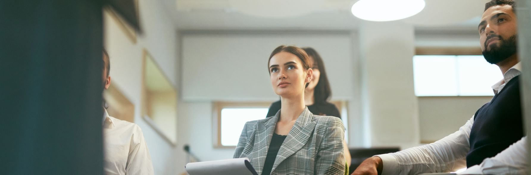 Business people in a meeting, with two looking forward.