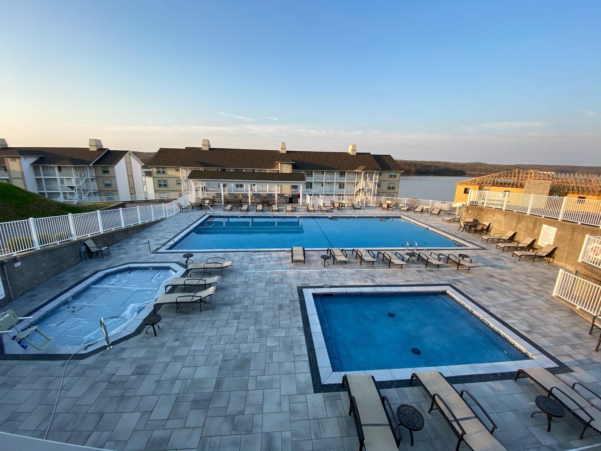 A large swimming pool surrounded by chairs and umbrellas