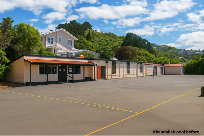 School building and playground, beige and brown, set against a hill. Sunny day.