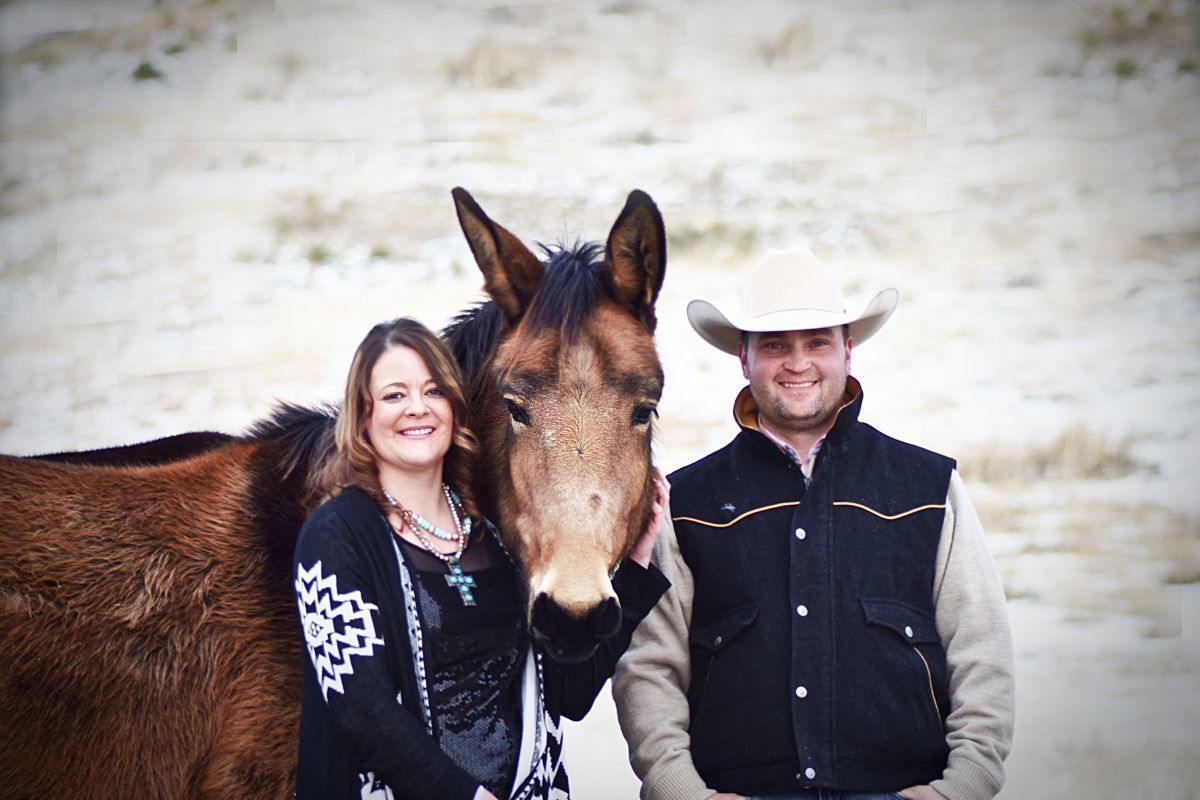 A man and a woman are standing next to a horse.