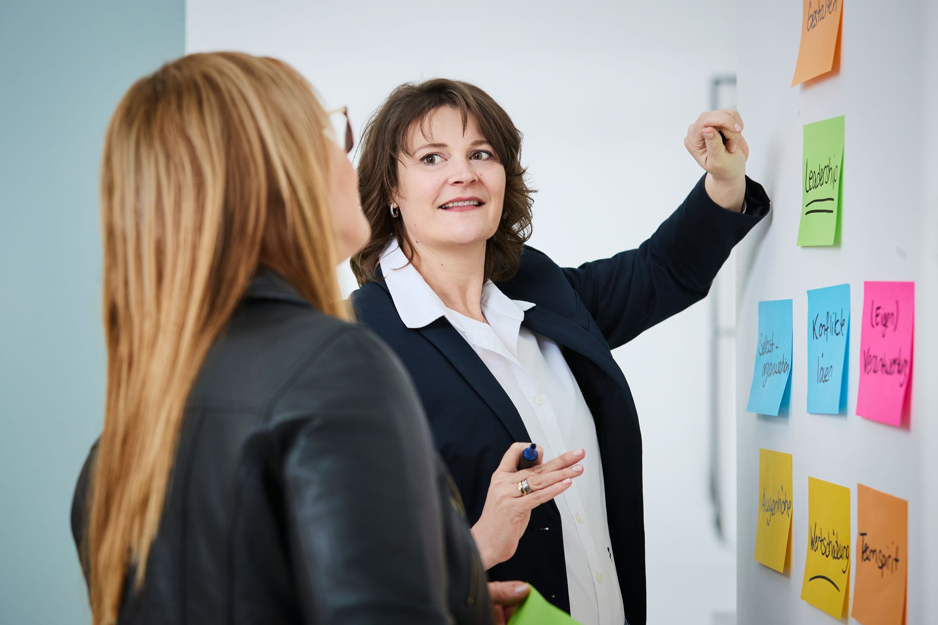 Eine Gruppe von Leuten sitzt um einen Tisch herum und sieht sich Baupläne an.