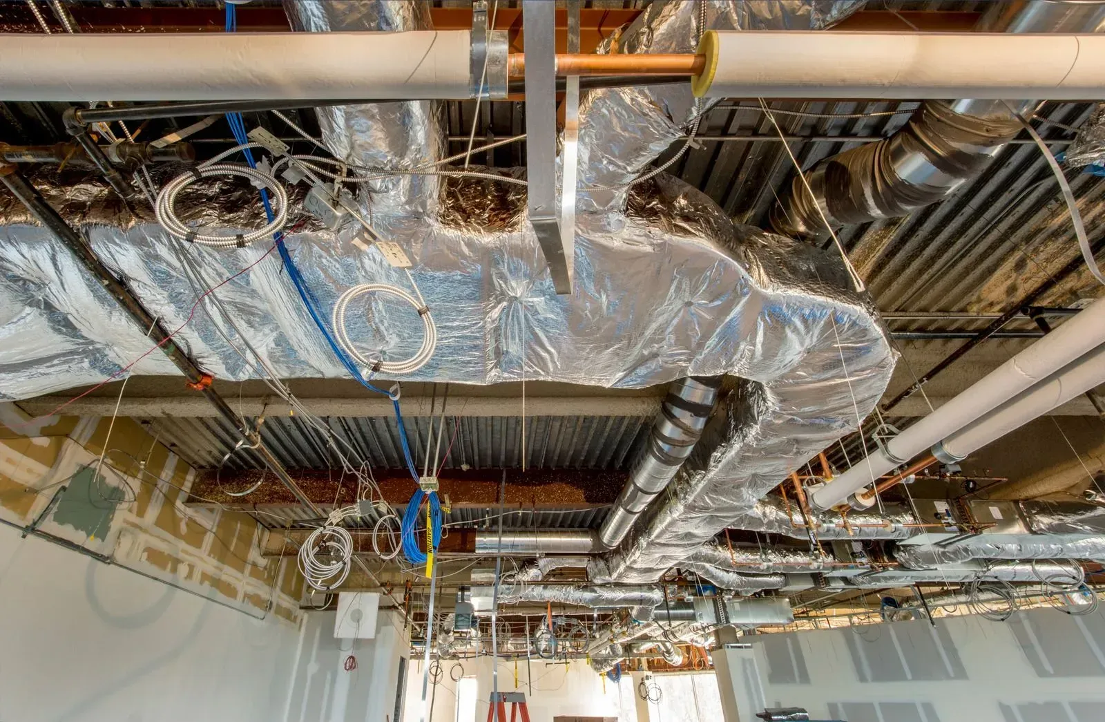 A room with a lot of pipes hanging from the ceiling.