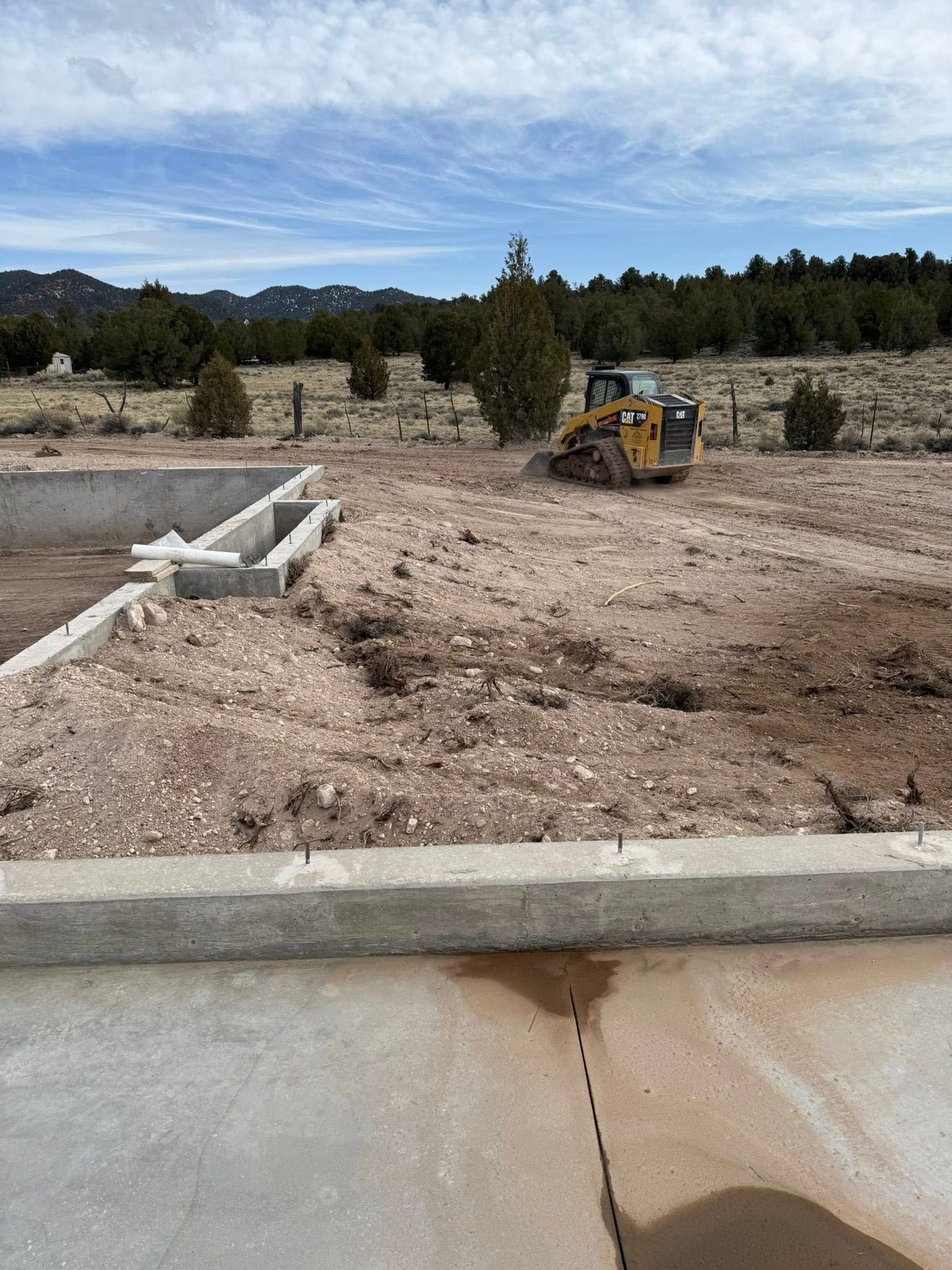A bulldozer is driving through a dirt field.