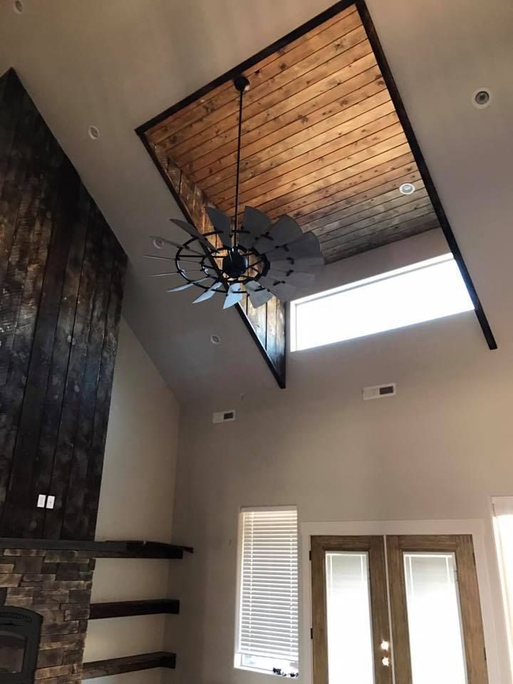 A living room with a ceiling fan and a fireplace.