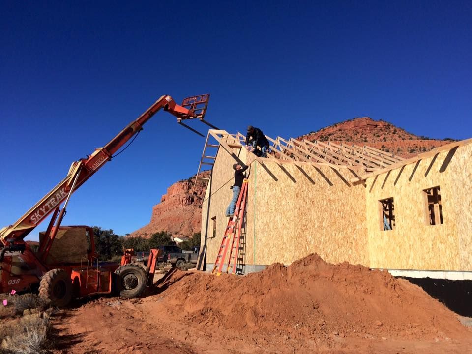 A crane is pouring concrete into a wooden wall.