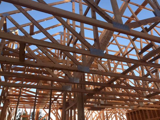 The ceiling of a building under construction with a blue sky in the background