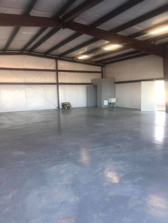 A large empty warehouse with a concrete floor