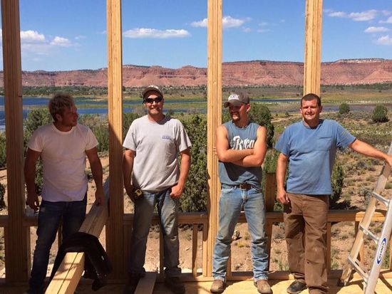 A group of men are standing in front of a wooden structure. Sugar knoll construction