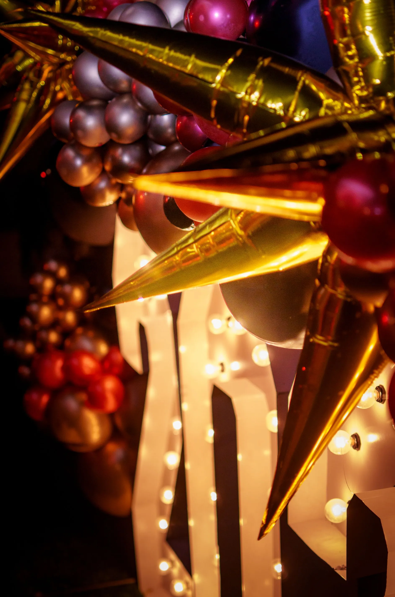 A close up of a sign with balloons and lights on it.