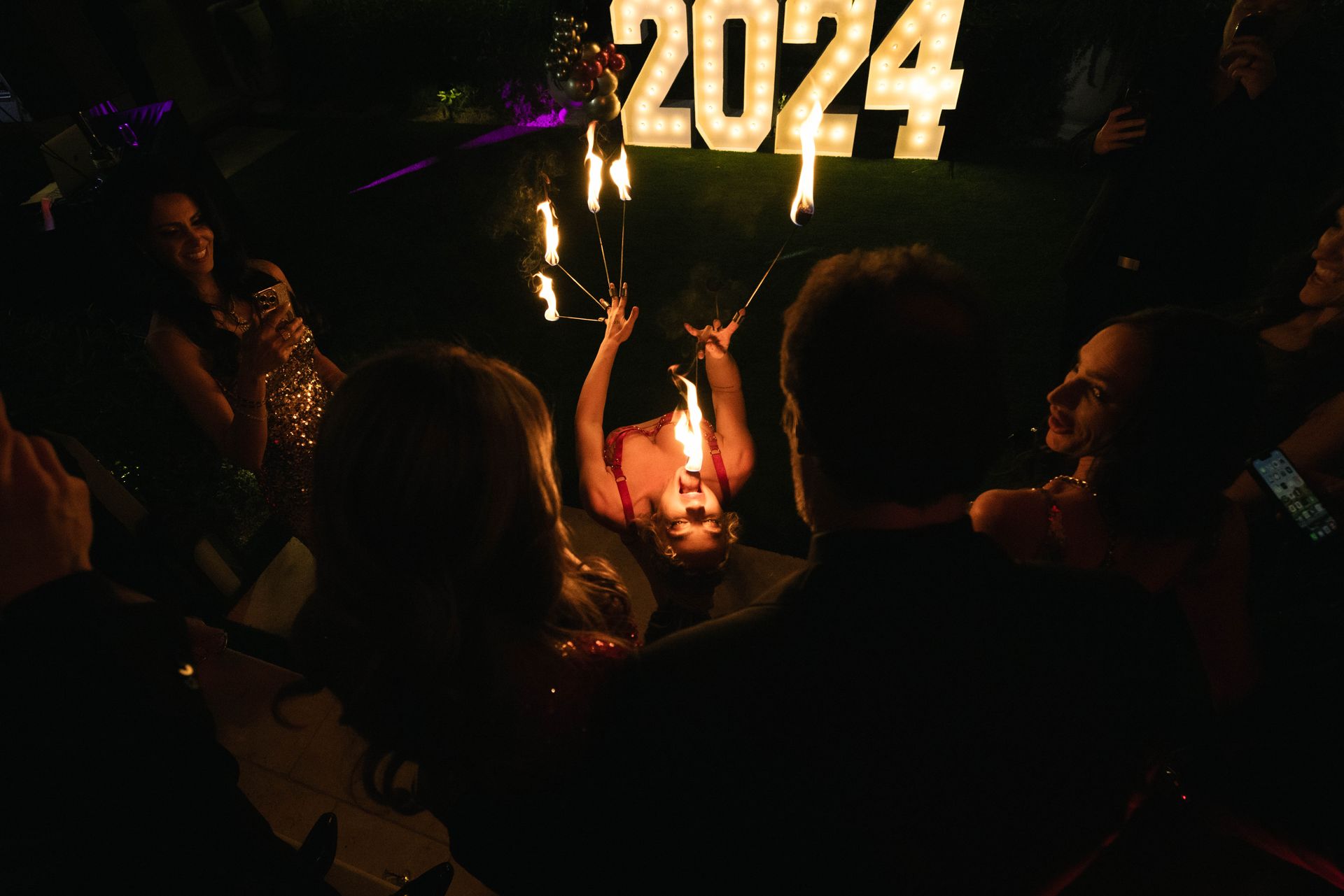 A woman is holding a torch in front of a sign that says 2024.