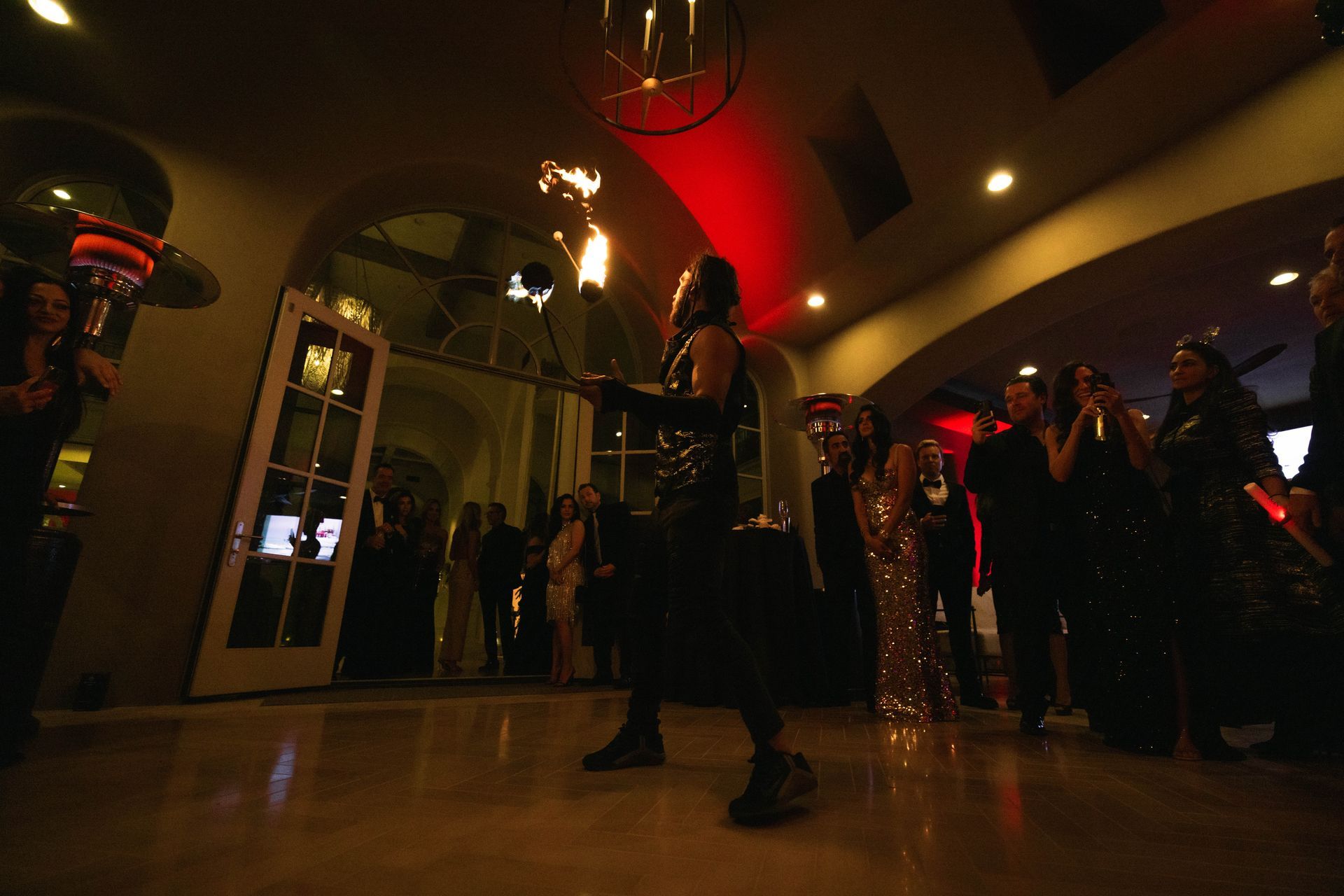 A woman is holding a torch in front of a crowd of people at a party.