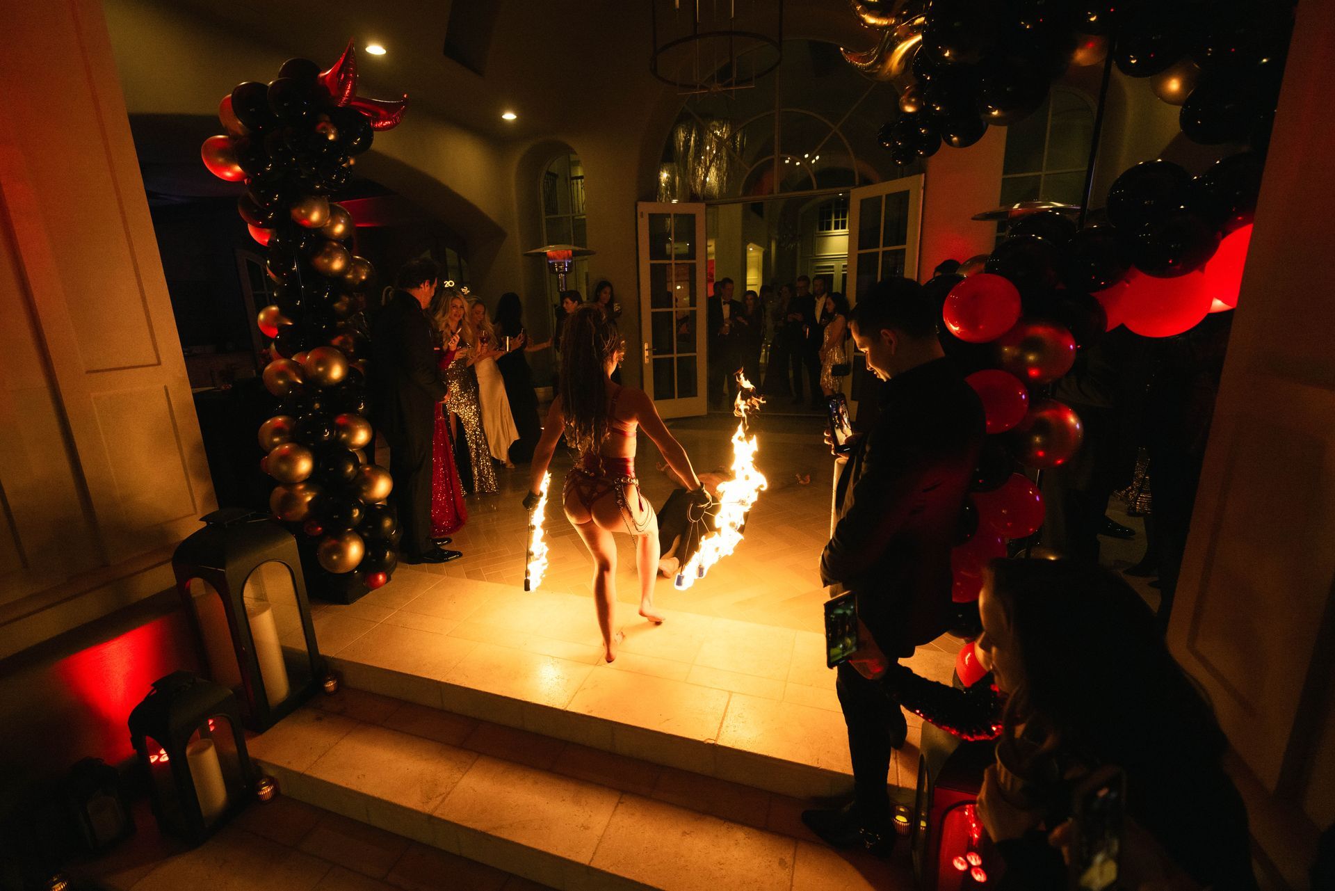 A woman is holding a fire torch in a dark room.