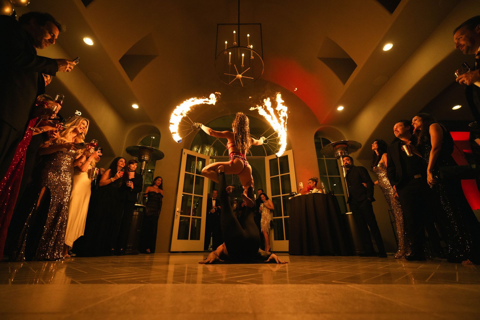 A group of people are watching a fire dancer perform