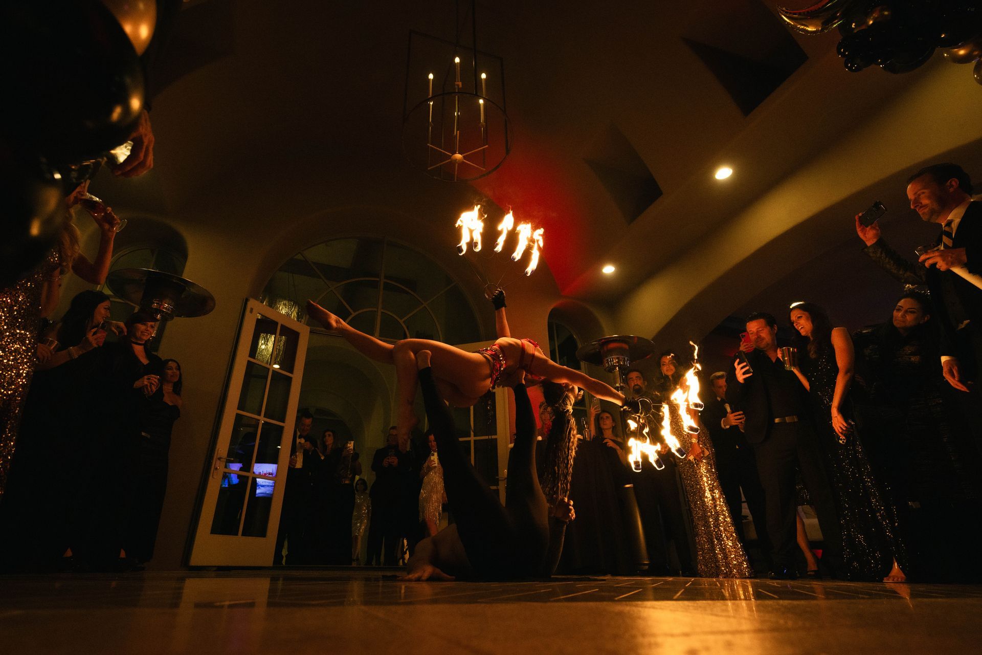 A woman is doing a handstand on a dance floor in front of a crowd of people.