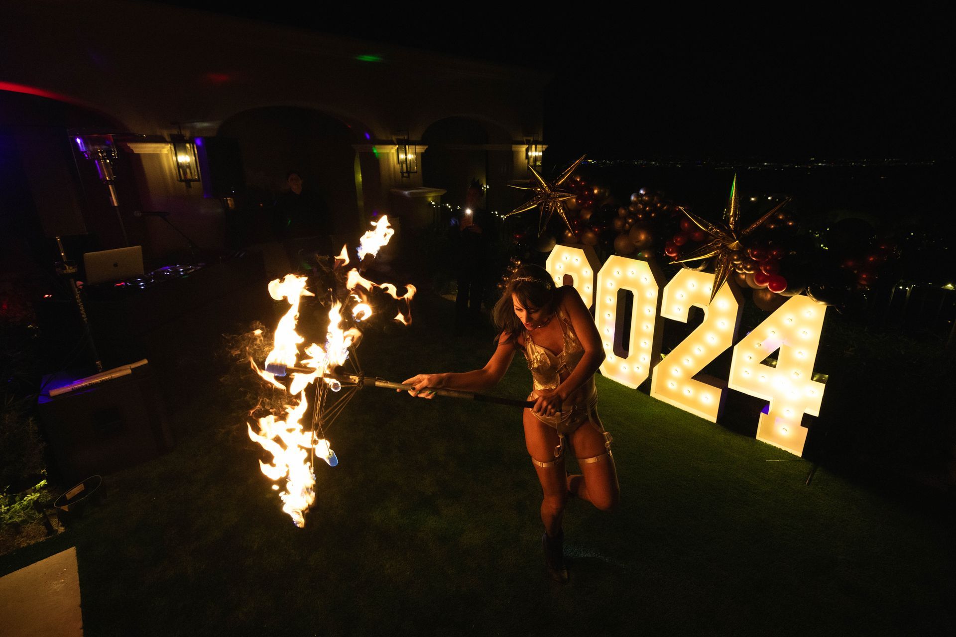 A woman is holding a torch in front of a sign that says 2024.