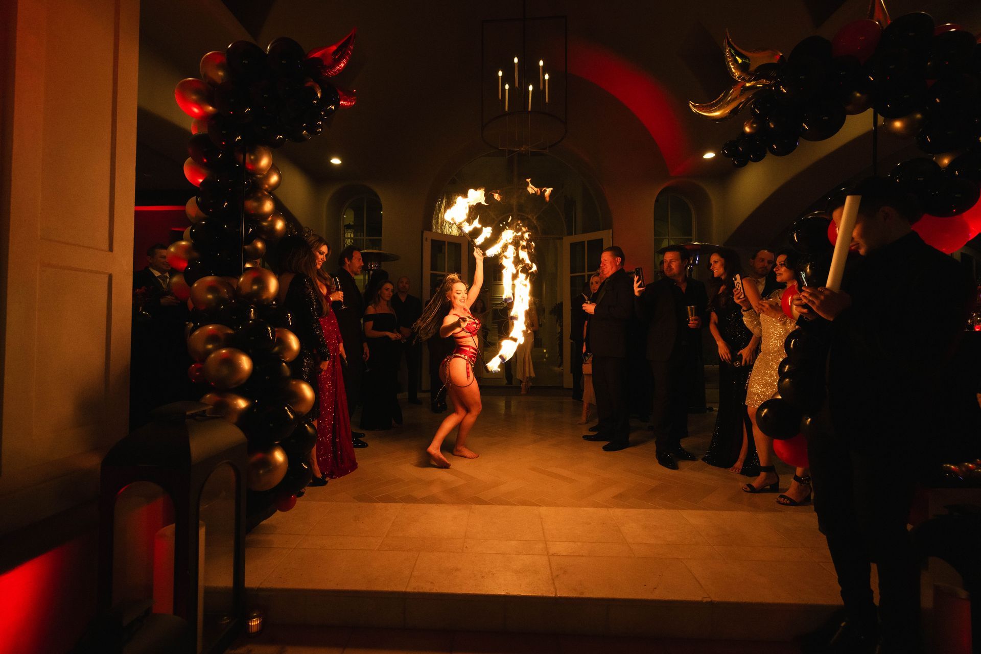 A woman is holding a torch in a room with balloons.