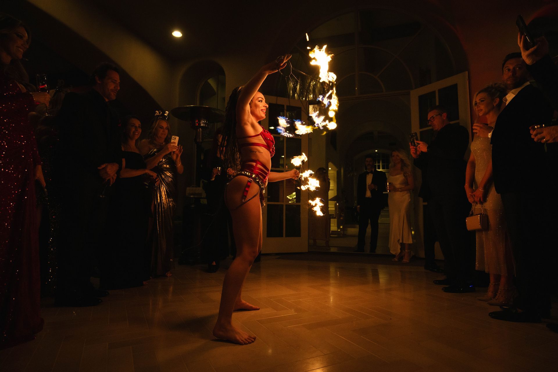 A woman is holding a torch of fire in a dark room.