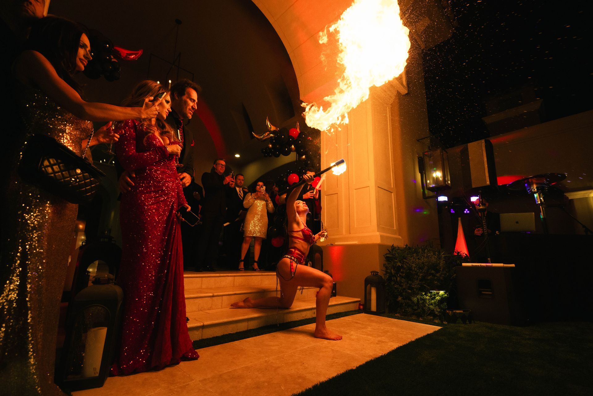 A woman in a red dress is holding a torch with flames coming out of it.