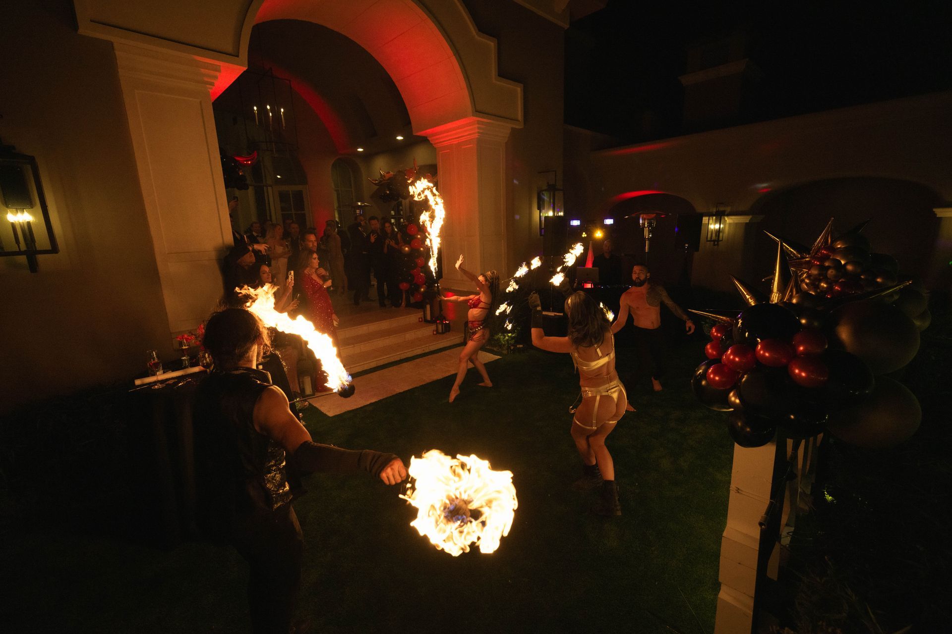 A group of people are holding fire torches in a dark room.