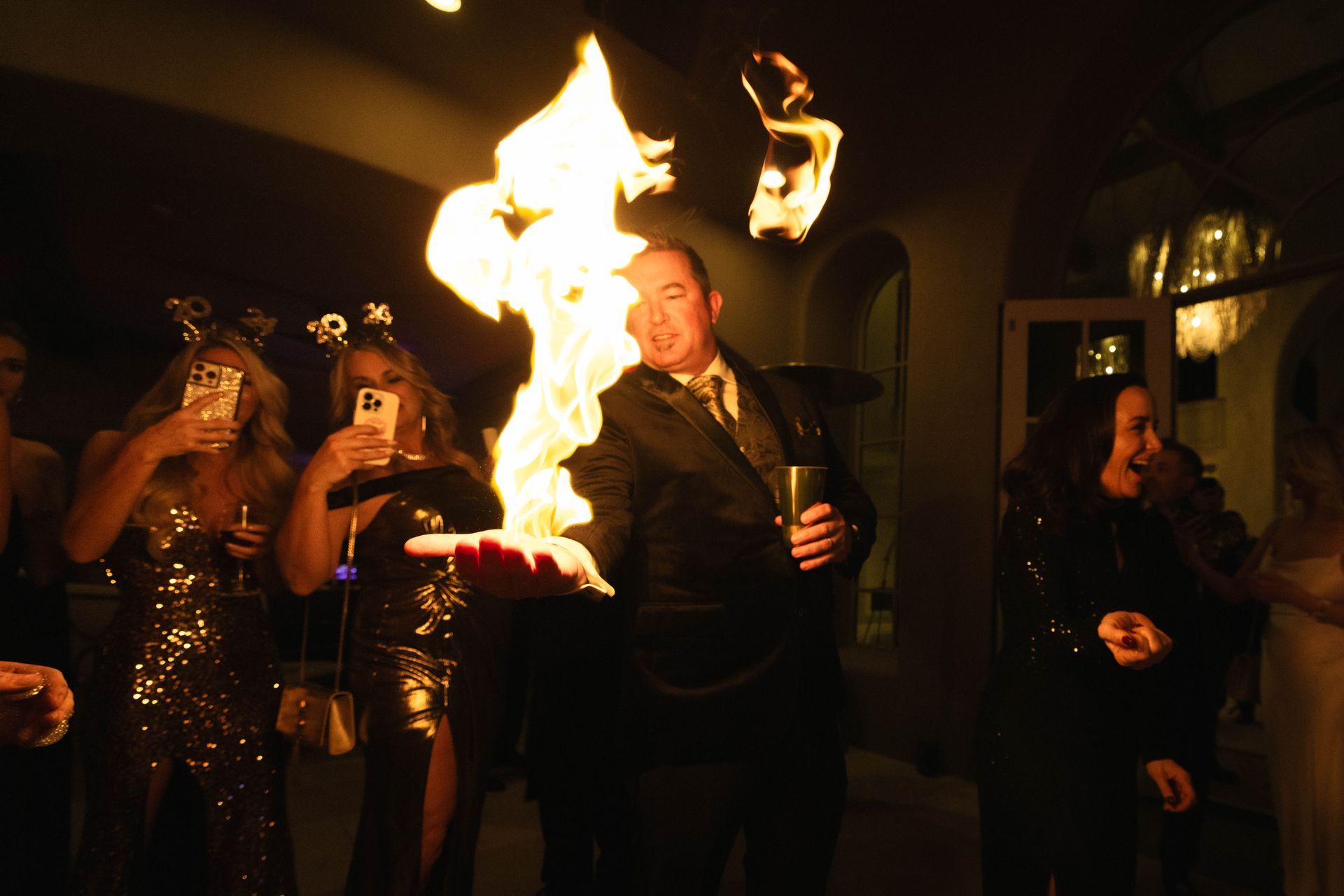 A group of people are standing around a man holding a fireball in his hand.