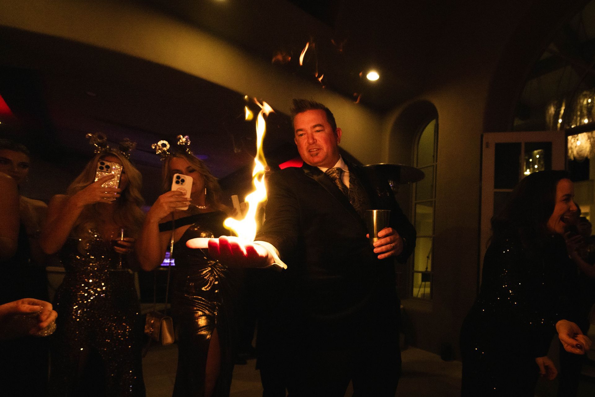 A man in a suit is holding a torch in front of a crowd of people