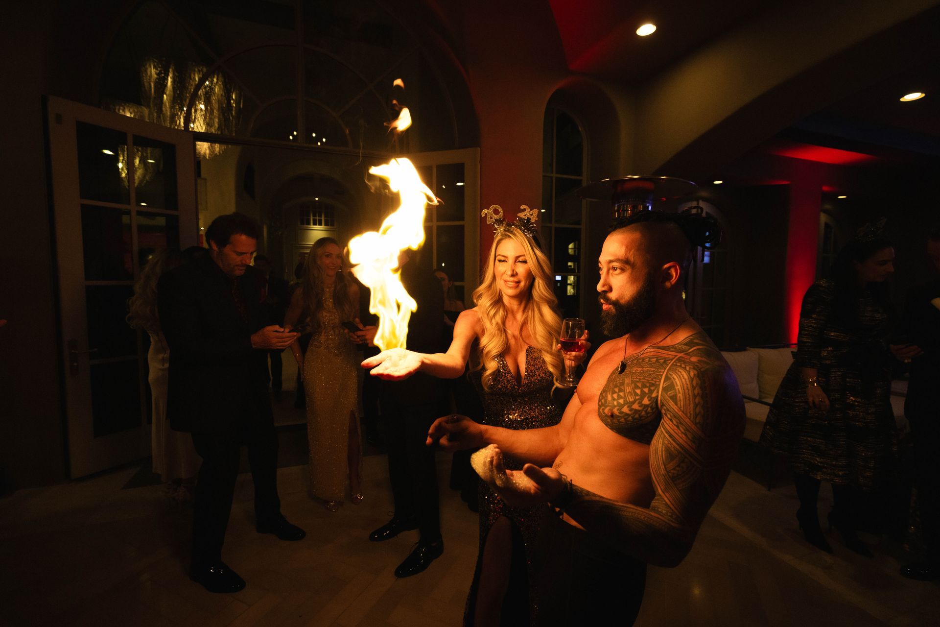 A group of people are standing around a man holding a fireball.