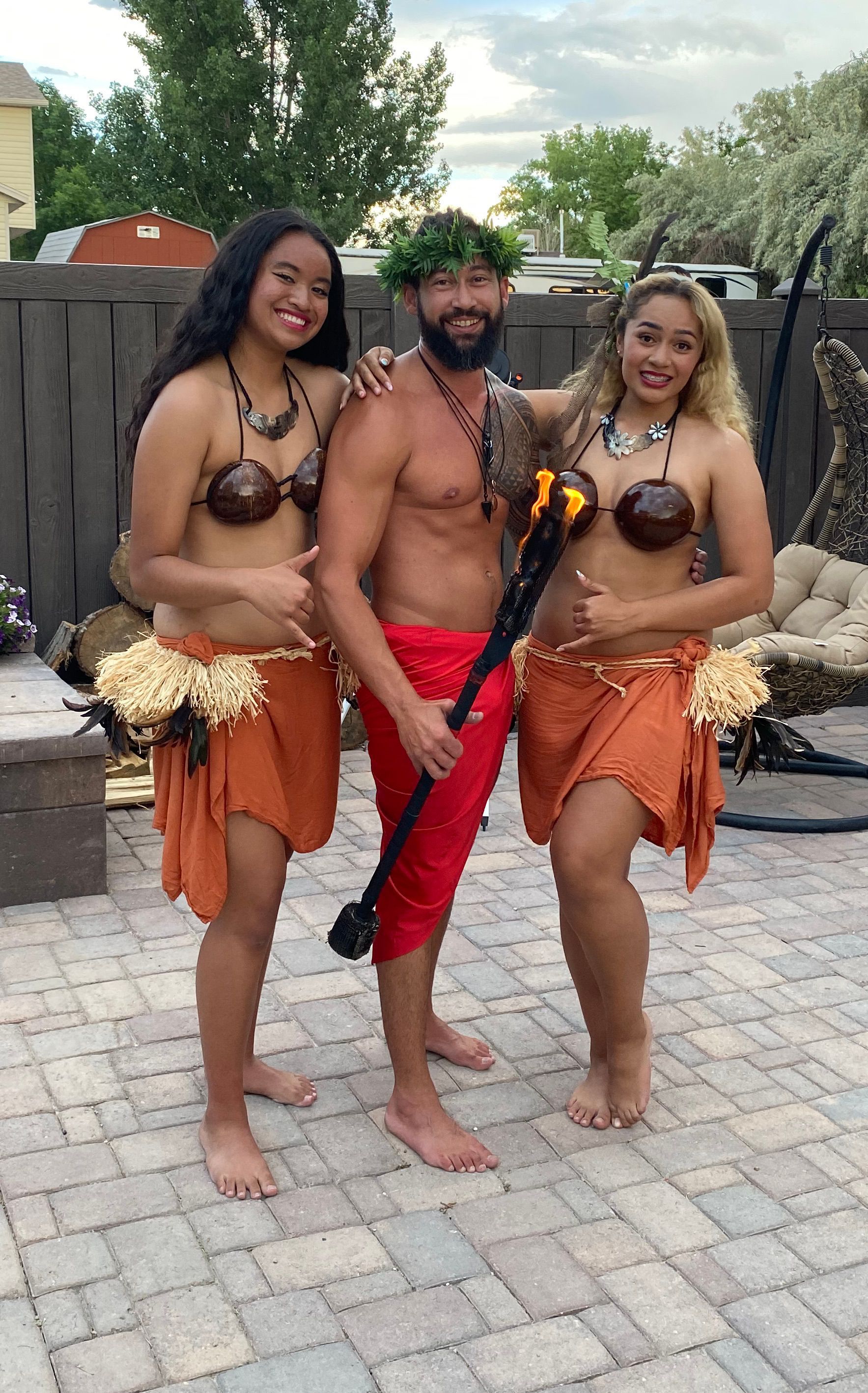 A man and two women are posing for a picture on a patio.