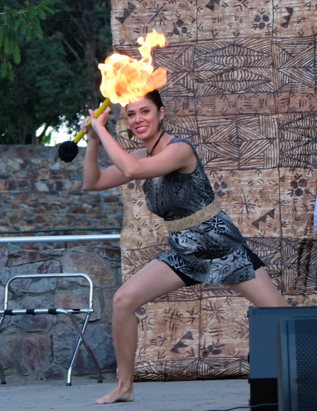 A woman is holding a torch with flames coming out of it