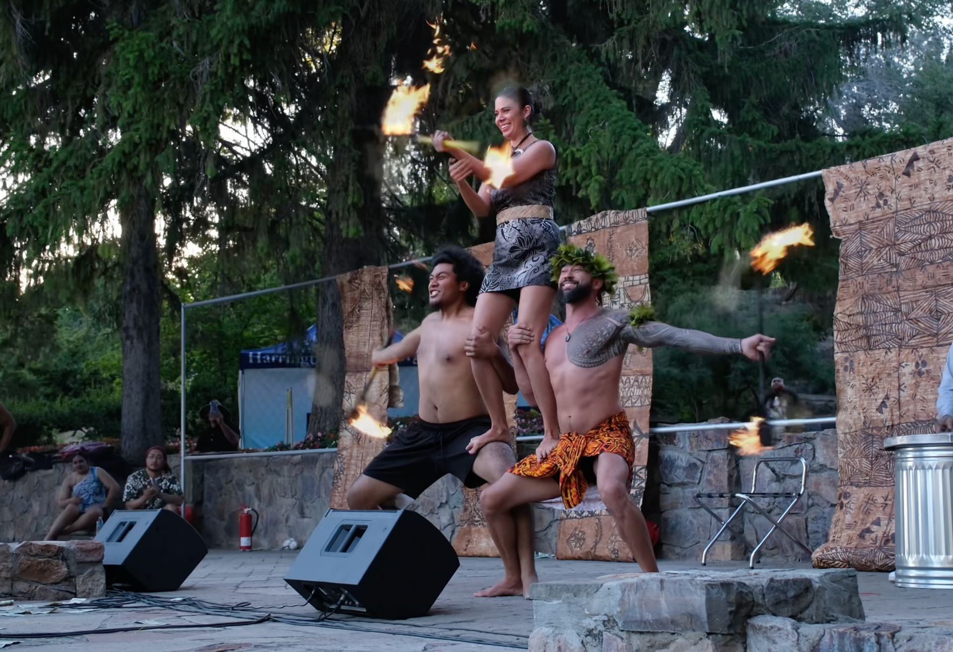 A group of people are performing on a stage with fire