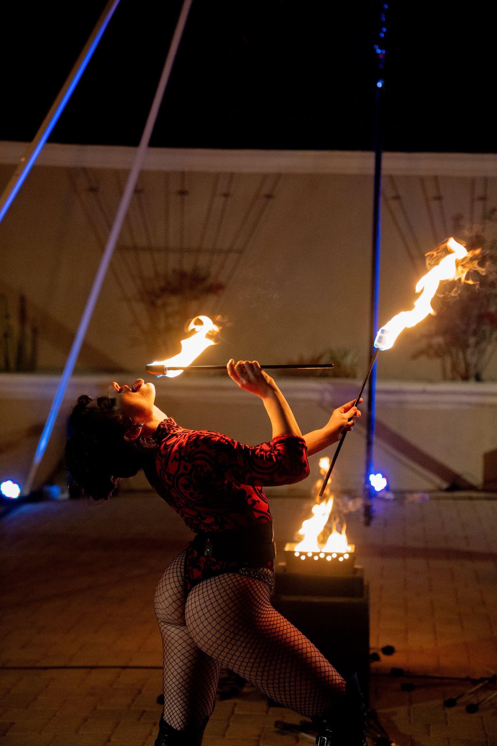 A woman is juggling fire in the dark.
