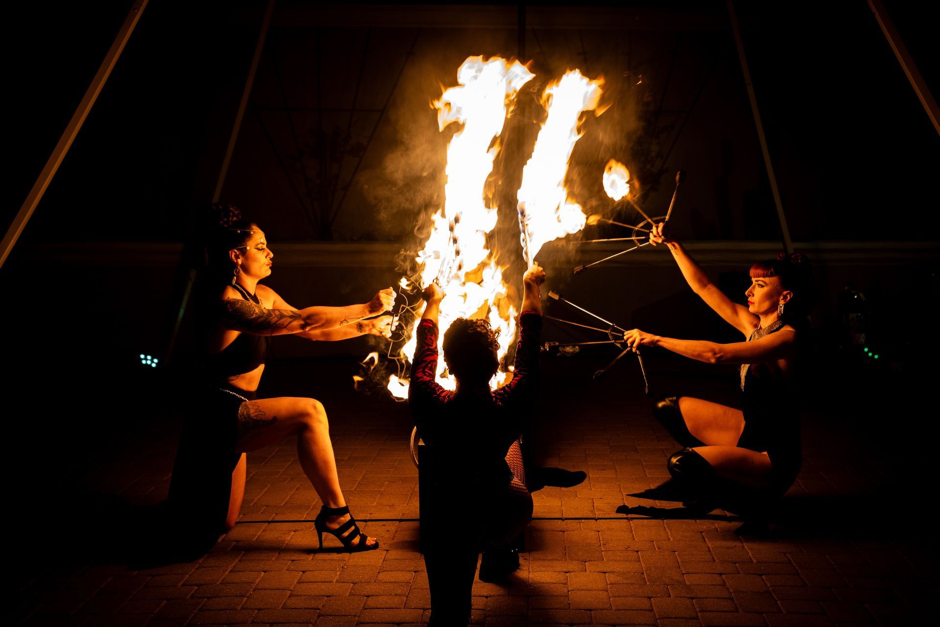 A group of people are performing a fire show at night.