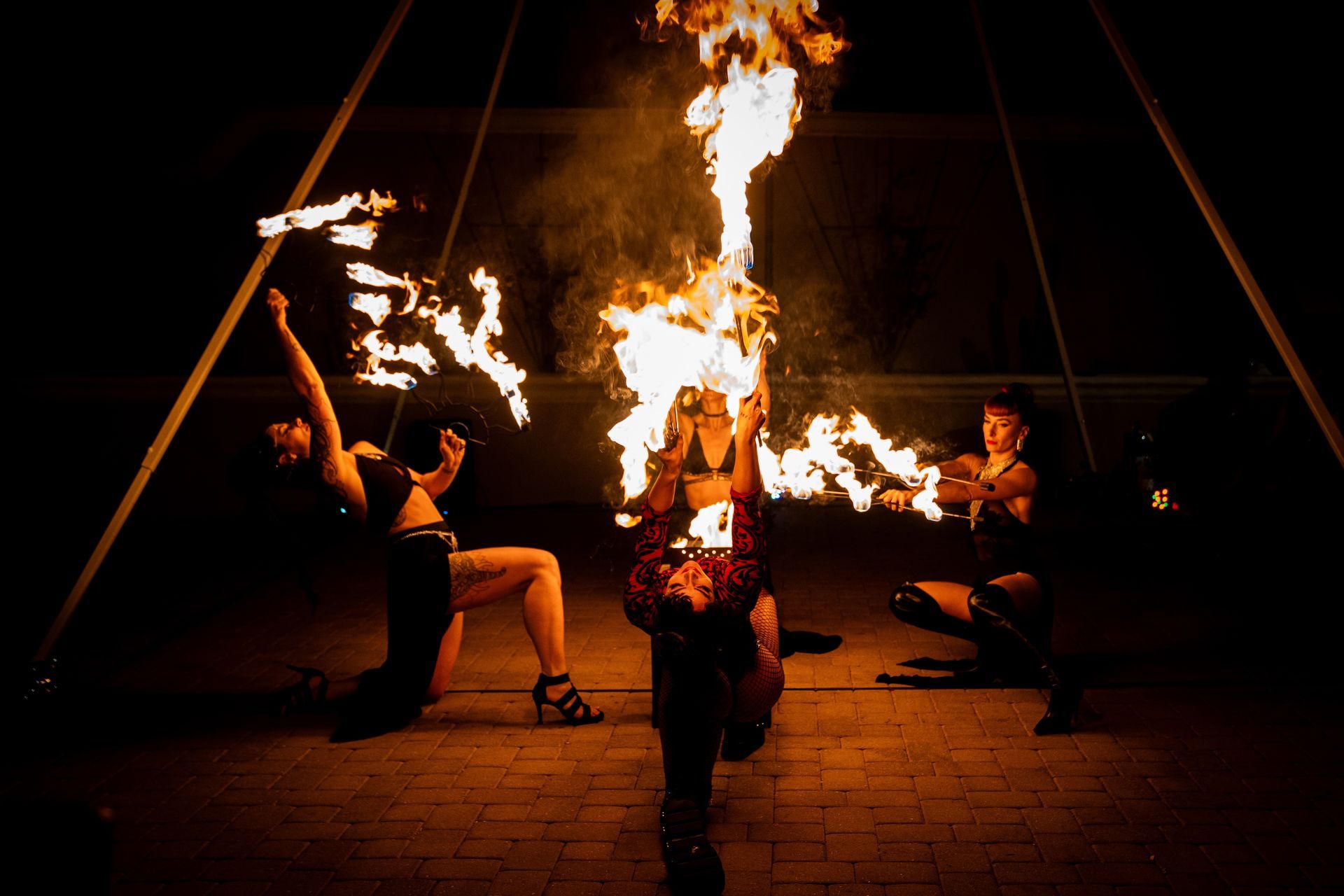 A group of women are performing a fire show at night.
