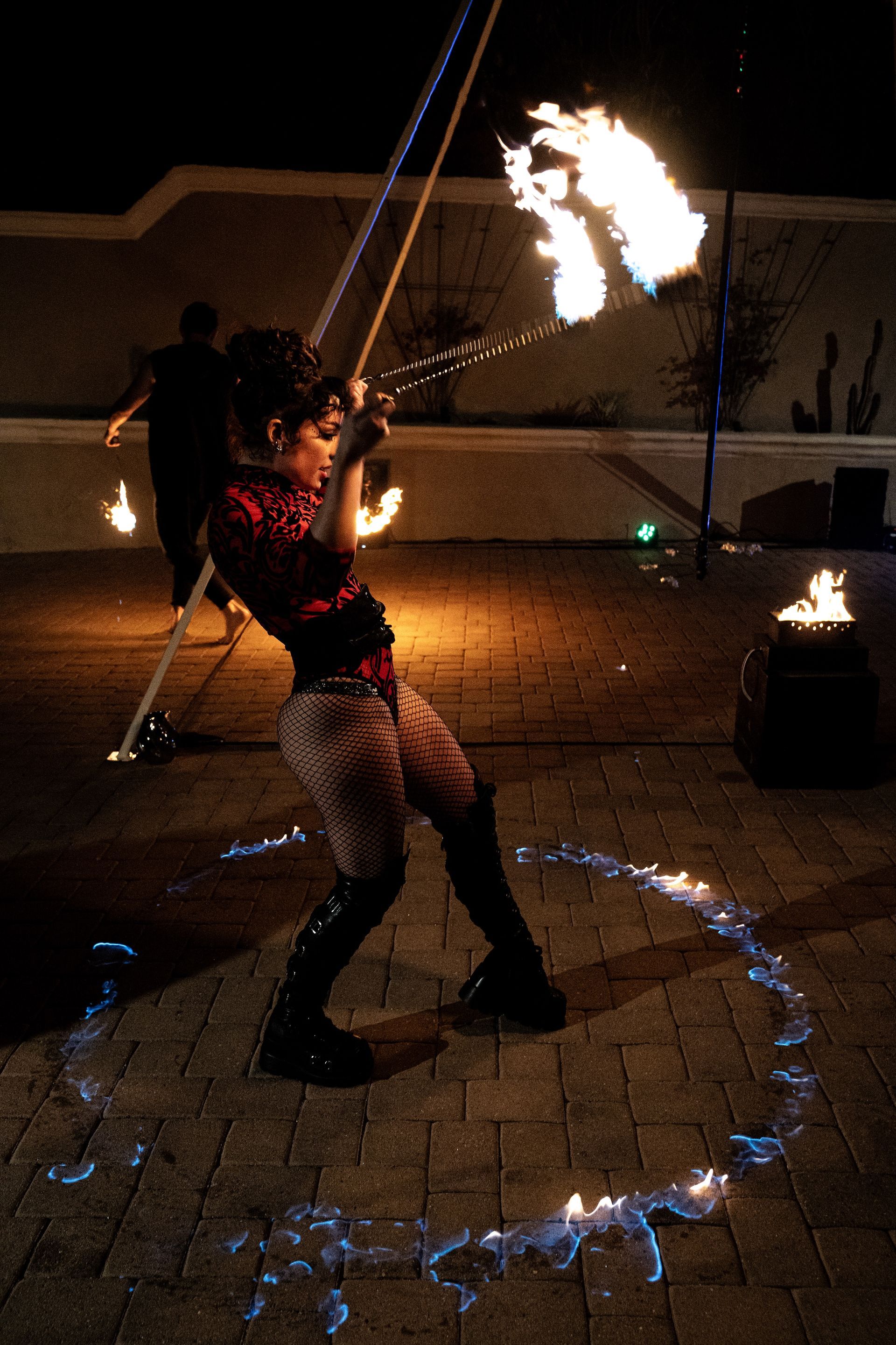 A woman is holding a rope with flames coming out of it