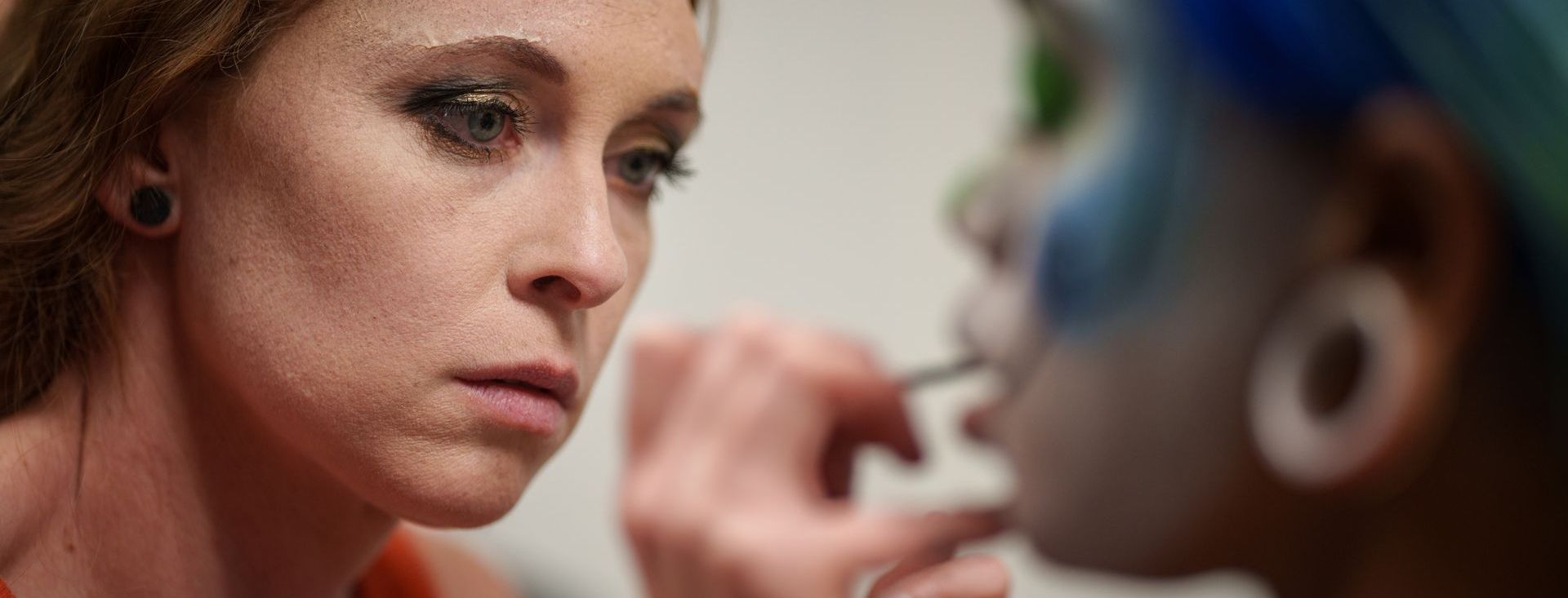 A woman is applying makeup to another woman 's face.
