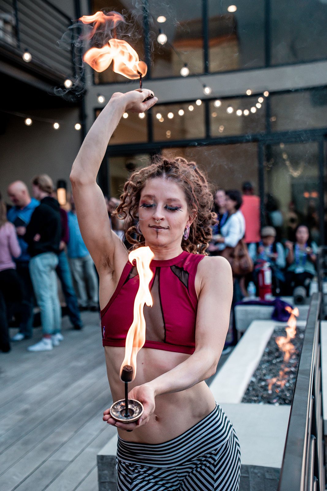 A woman is holding a torch with flames coming out of it.