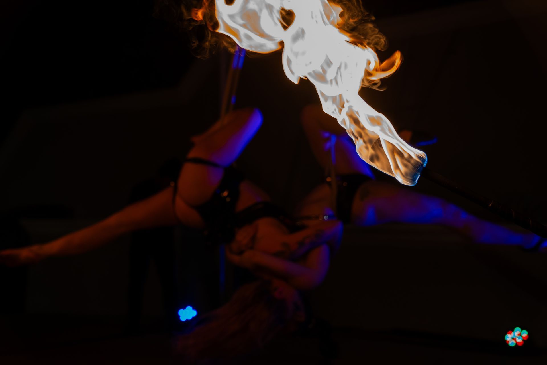 A woman is holding a stick with fire coming out of it.