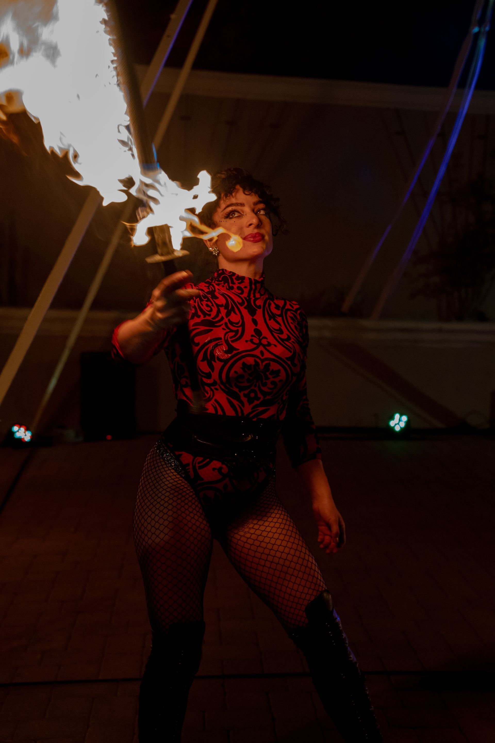 A woman is holding a torch with flames coming out of it.