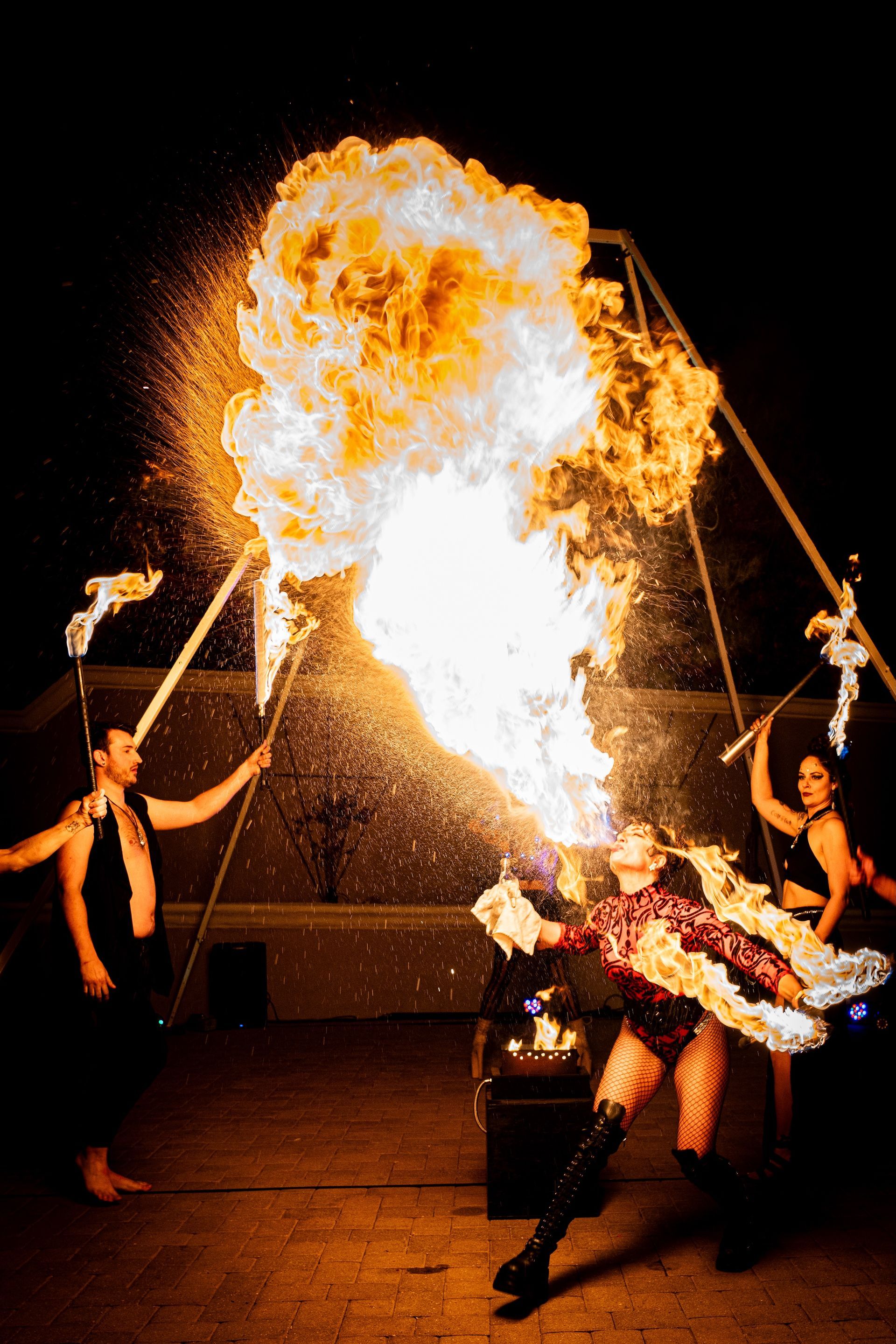 A group of people are performing a fire show at night.