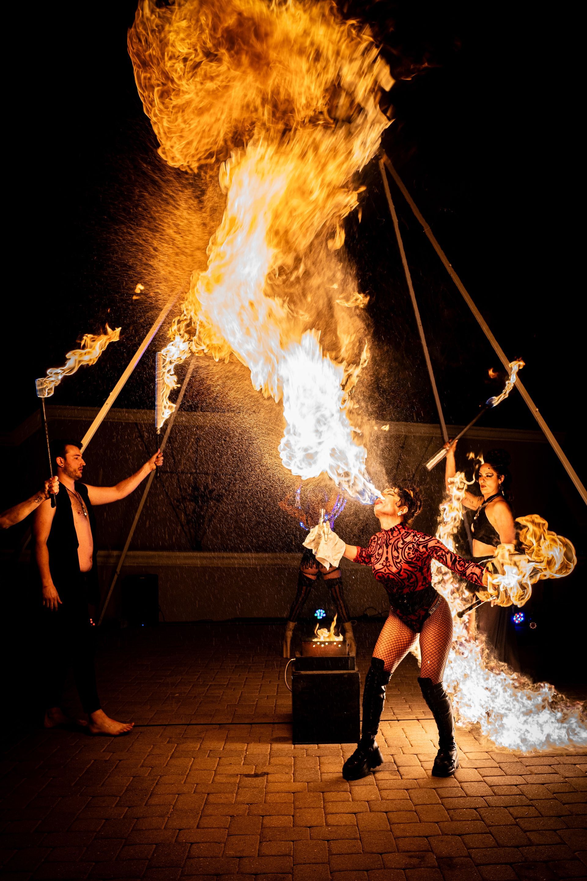 A group of people are performing a fire show at night.
