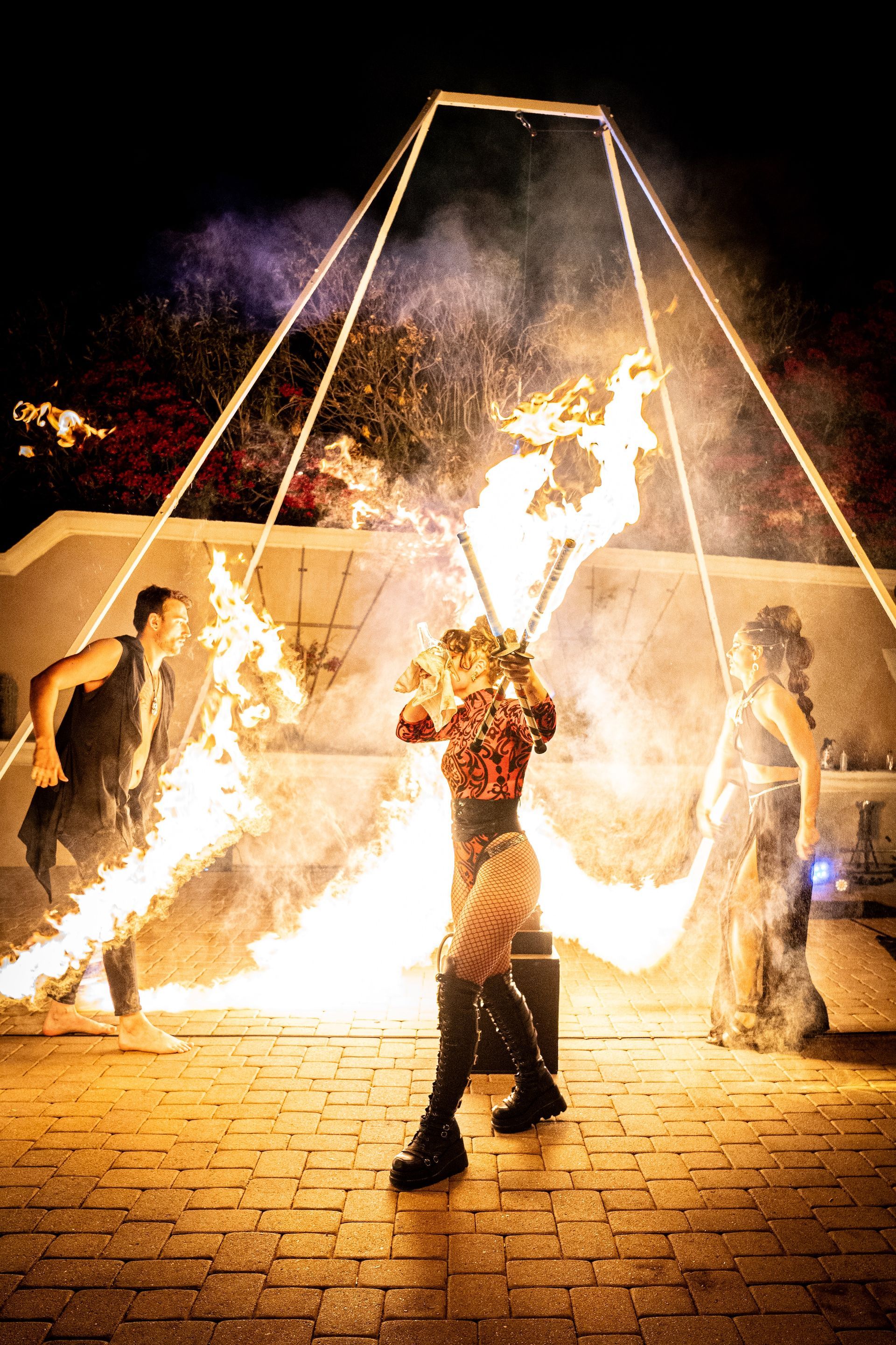 A group of people are performing a fire show at night.