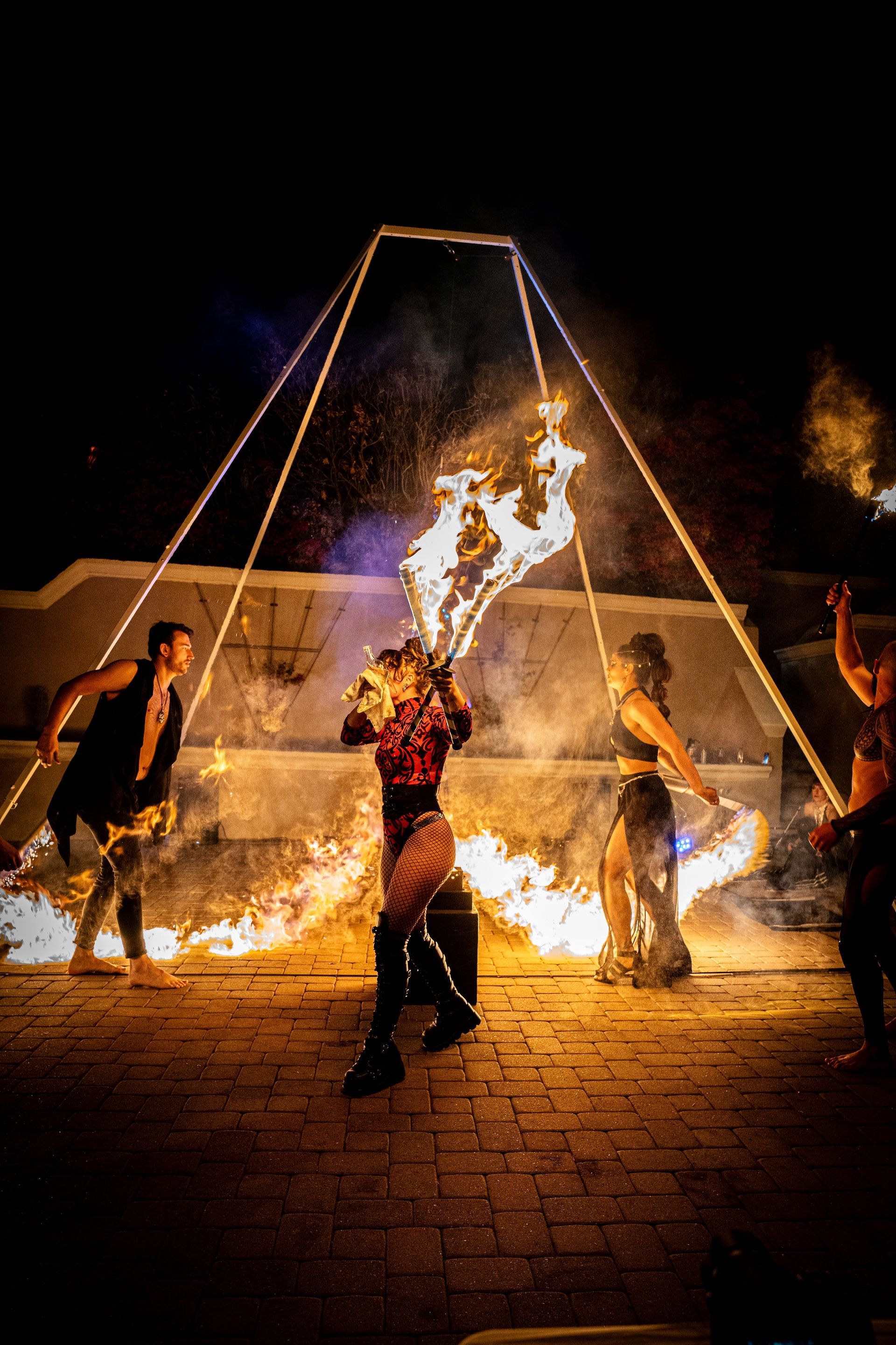 A group of people are performing a fire show at night.