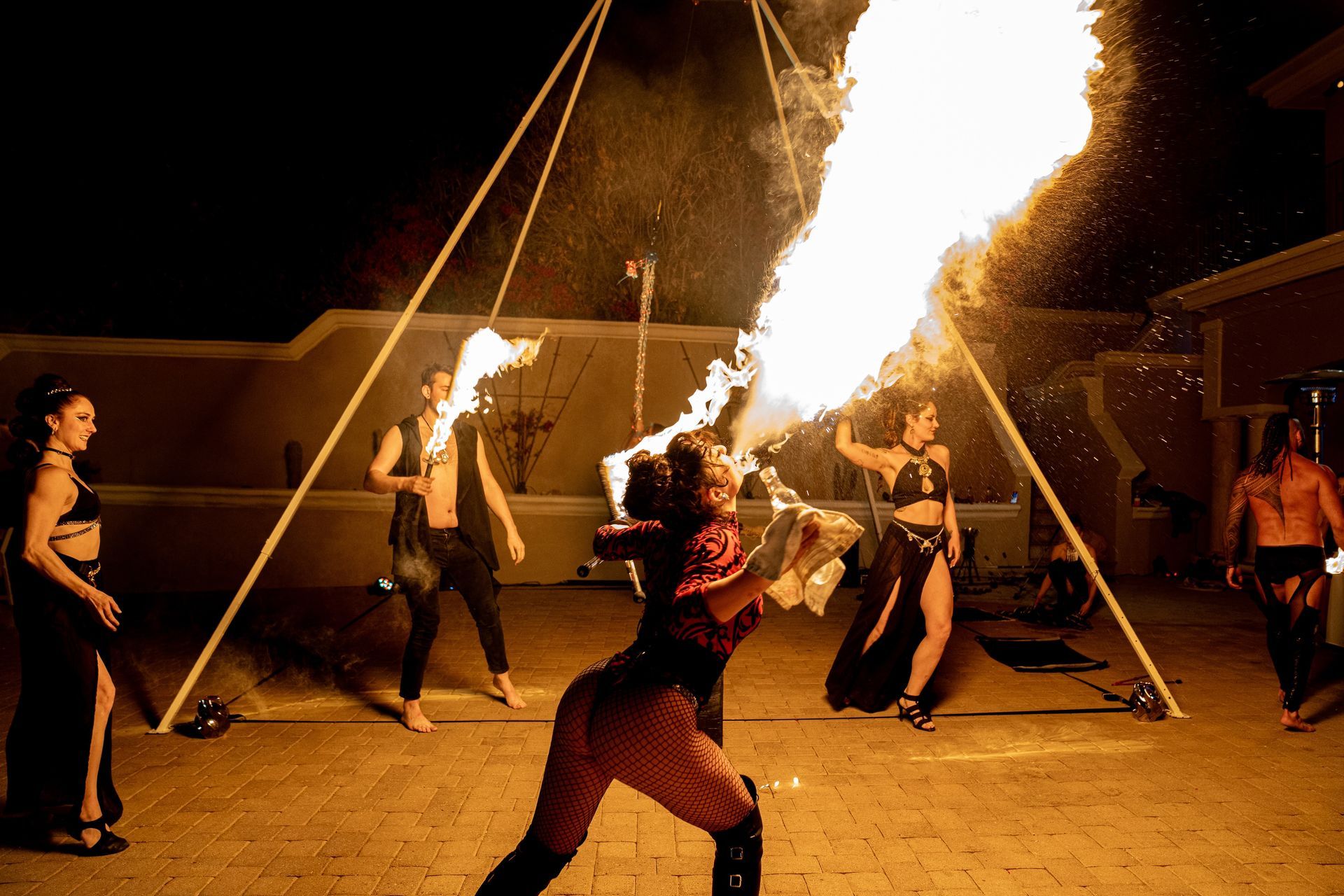 A group of people are performing a fire show at night