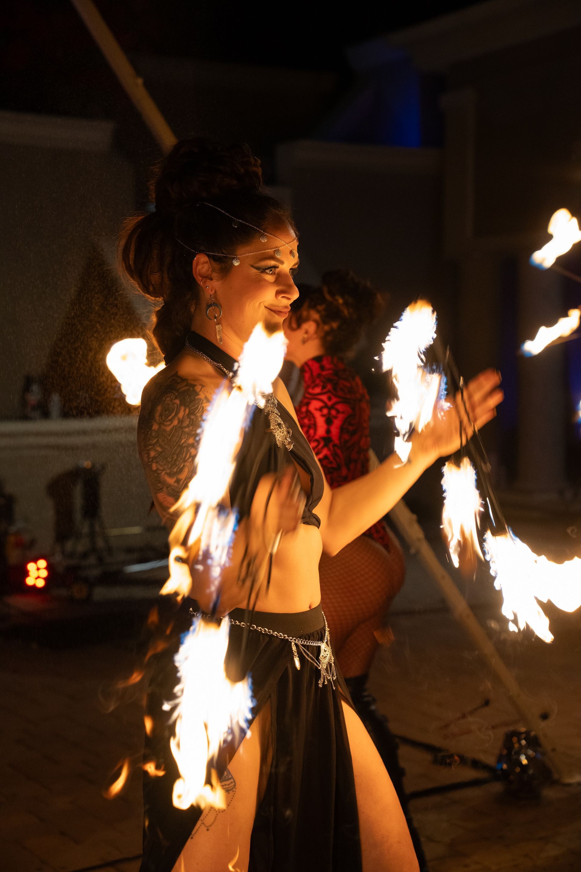 A woman is holding a stick of fire in her hand