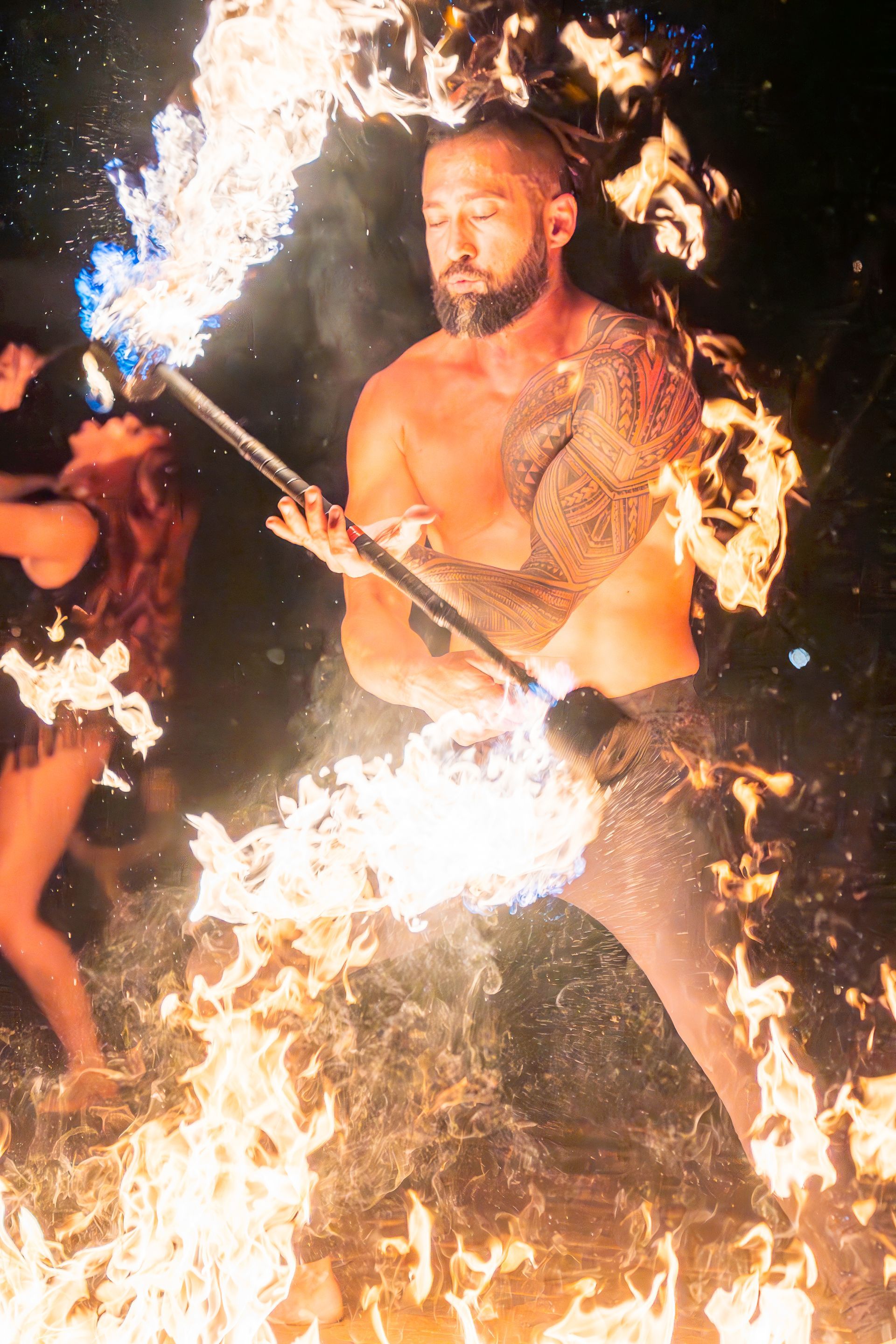 A man is holding a torch in front of a fire.