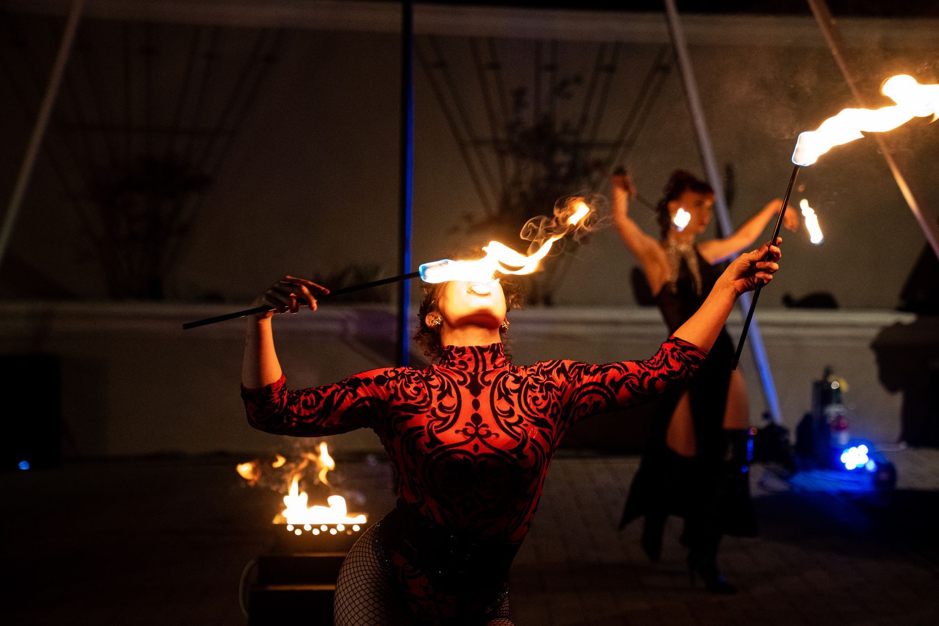 A woman placing fire on her tongue.